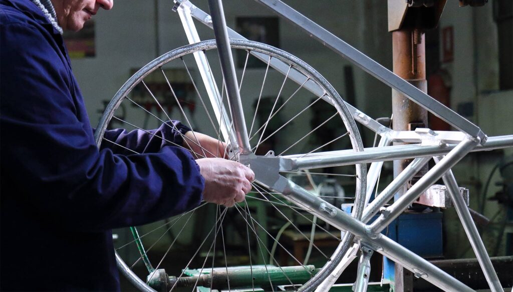 artigiano lavora su telaio bicicletta